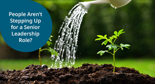 A close-up image of a small plant being watered, symbolizing growth and development, with a text overlay asking if people aren't stepping up for senior leadership roles.