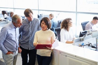 Casually dressed staff standing in a busy open plan office