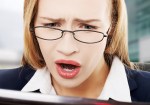 Shocked, surprised business woman sitting in front of laptop