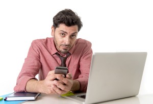Young Attractive Businessman Working At Office Desk With Mobile
